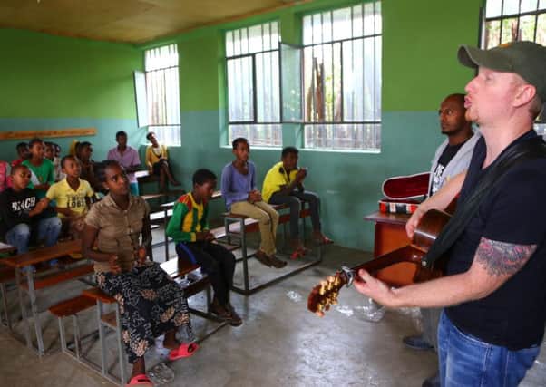 Wes Grierson teaches children in Ethiopia his song "So much more than Christmas Day." INNT 51-818CON