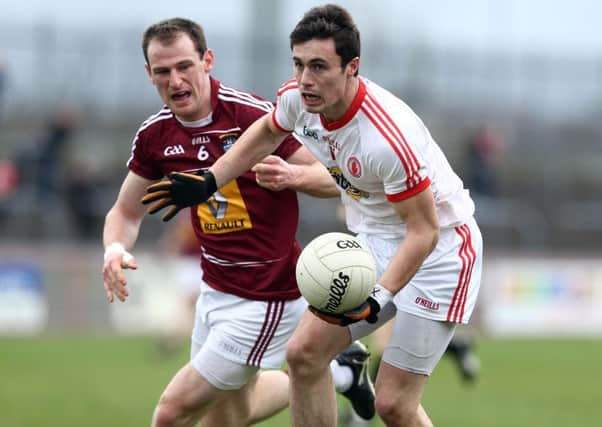 Shay McGuigan makes a pass under pressure from Westmeath's John Gilligan.