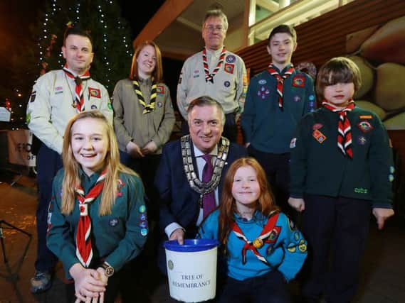 Gary Corkin, President of Lisburn Rotary Club (centre) pictured with some of the Lisburn Scout Group who are helping to man the 'Tree of Remembrance' during the run up to Christmas. (Front right) Rebecca Murray, 15, (front left) Kathryn Murray. (Back l-r) Johnny Simpson, Annie Taylor, Andrew Stacey,  Matthew Murray and Ethan Simpson. Picture By Phil Smyth Photograph