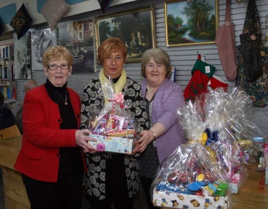 The President of Ballymoney Chamber of Commerce, Mrs Winifred Mellett, hands over one of the baskets of gifts to Open Door volunteers Grace Hartin (right) and Florence Jackson on behalf of Millside Restaurant, Cloughmills.The donations will be distributed to the needy in the Ballymonery area before Christmas.