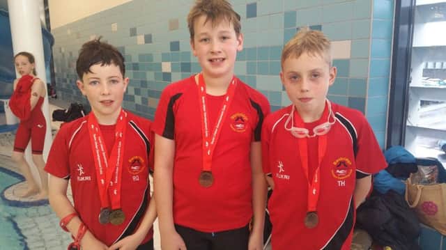Showing off their medals are Banbridge ASC swimmers Ronan Quinn, Isaac Forsthye and Taylor Hill.