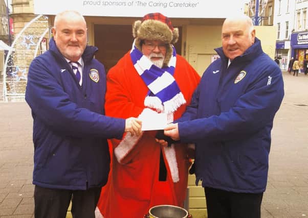 Ivan Kyle and Jimmy Boyce from Coleraine FC present Davy Boyle with a donation on behalf of the club.