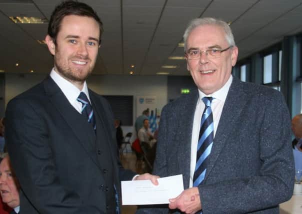 Neil Coleman presents a cheque, part proceeds from his recently published book on the history of Ballymena United, to John Anderson, of Ballymena United Youth Academy.