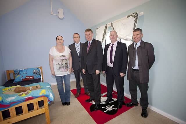 Mary Madison shows off her son Carsons new purposebuilt bedroom to Paul Isherwood, Director of Asset Management at the Housing Executive, DSD Minister Mervyn Storey, Brendan Doherty, Housing Executive Area Manager and Housing Executive Design Group architect, Alistair Neeson.