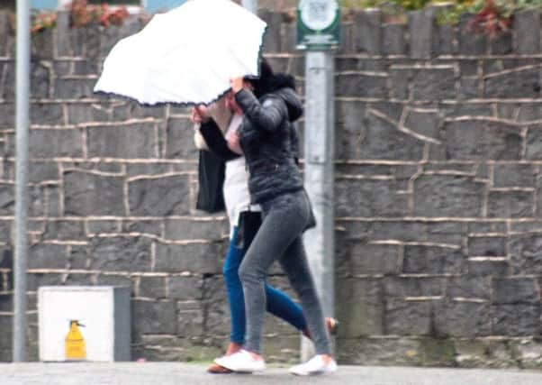 Two women struggle with their umbrella while out and about during Storm Frank 

Picture Michael Cowhey.