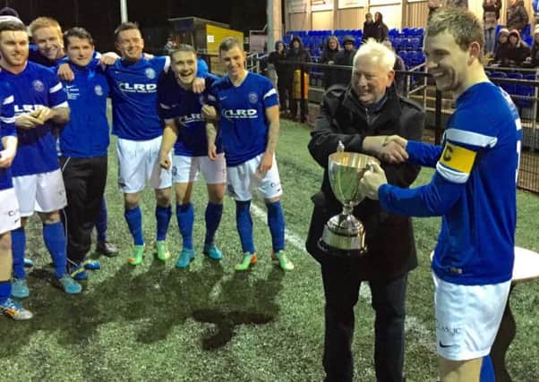 Limavady United skipper Hugh Carlin receives the Craig Memorial Cup from Billy Smallwoods.