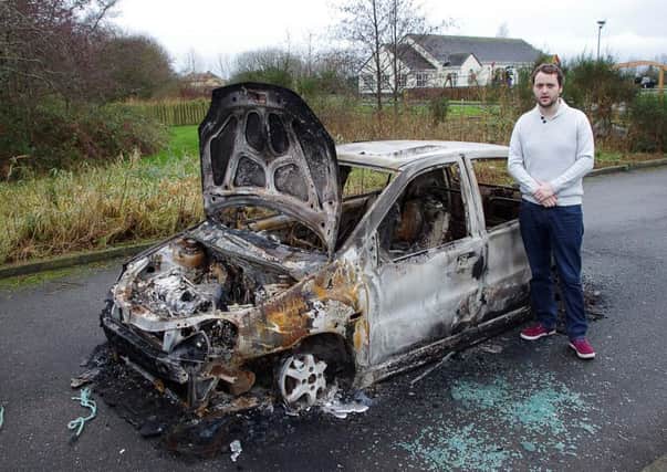Torrent SDLP councillor Malachy Quinn surveys the burned car at Washingbay.