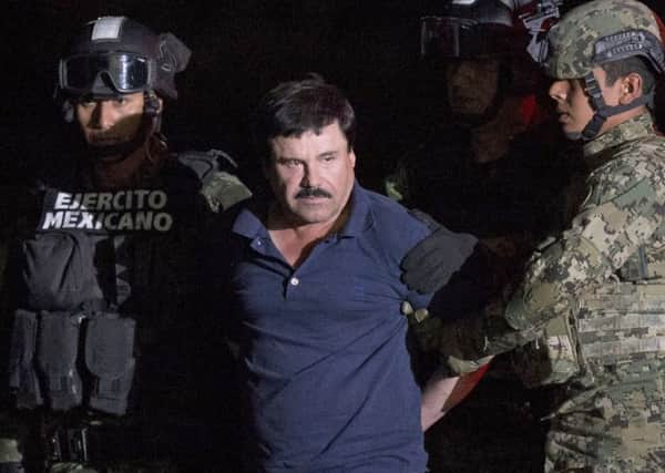 ALTERNATIVE CROP OF RLB111.- Mexican drug lord Joaquin "El Chapo" Guzman is escorted by army soldiers  to a waiting helicopter, at a federal hangar in Mexico City, Friday, Jan. 8, 2016. The world's most wanted drug lord was recaptured by Mexican marines Friday, six months after he fled through a tunnel from a maximum secuirty prison in a made-for-Hollywood escape that deeply embarrassed the government and strained ties with the United States. (AP Photo/Rebecca Blackwell)