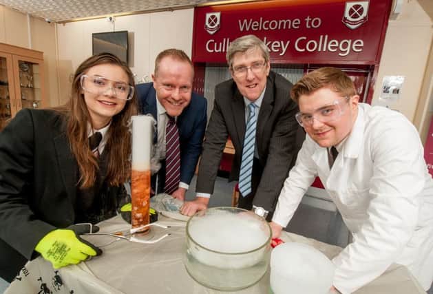 Cullybackey College pupils Simone Lyle and Robert Anderson join Education Minister John O'Dowd and Principal David Donaldson at the school's interactive science day, as they try to create dry ice bubbles.