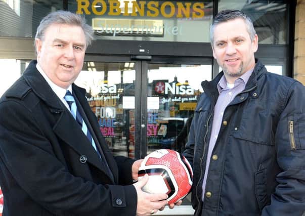Gary Olphert, Manager of Robinsons Nisa Extra, Cullybackey Road, presents Sales and Marketing Executive Brian Thompson with a match ball for Ballymena United's home match against Carrick Rangers.