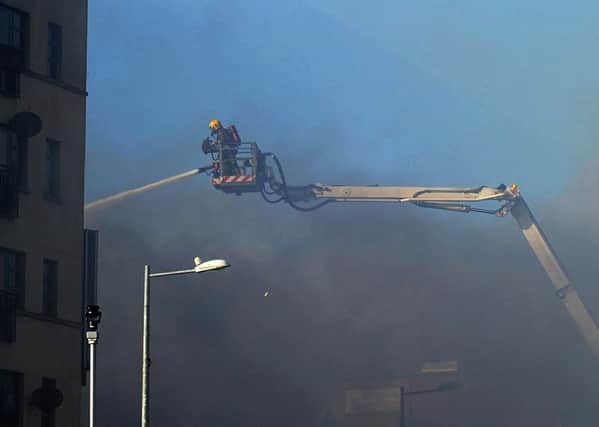 A firefighter moves in on the turntable ladder during last year's blaze at the Mandarin Palace restaurant along Queens Quay. DER1015MC106