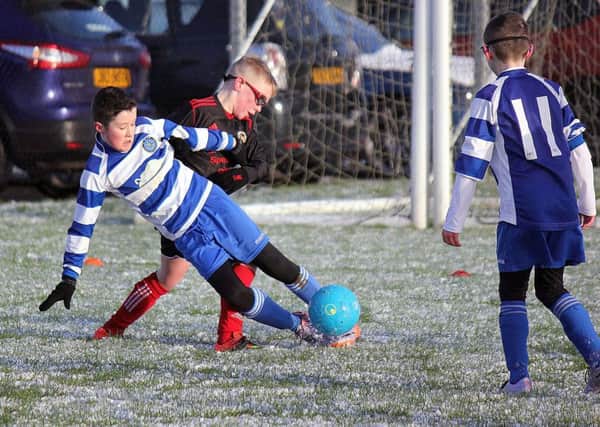A Northend under-11 player finds the slippery underfoot conditions difficult during Saturday's NIBFA Cup match against Hillsborough. INBT 06-862H