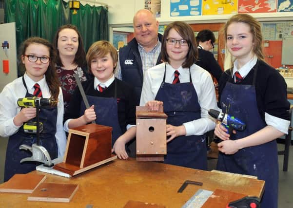 Ballymena Academy Young Environmentalist Society pupils Anna Maybin, Hannah McVicker, Kezia Mitchell and Alex Balmer are seen here with teacher Mrs N Kerr and senior lab technician Mr W Warwick as they make bird boxes which will be placed in trees in the school grounds. INBT 06-101JC