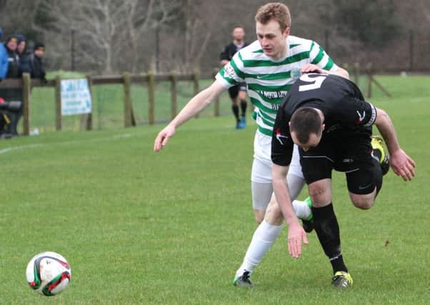 Lurgan Celtic's Aaron Haire stays on his feet as his Knockbreda opponent trips up. INLM06-616AM