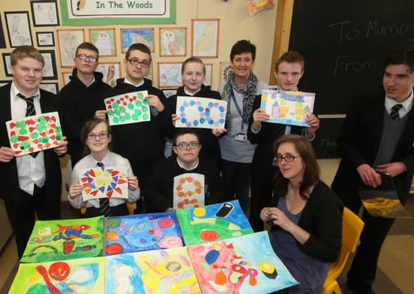 Pupils from Castle Towers with some of their work which will feature in a mural to be hung in Antrim Area Hospital. The students who have been working with Artist Helen Bradbury (seated) for the past few months are seen here with her and teacher Marie O'Connor. INBT 07-113JC