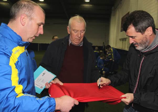 Liam Smyth holding a shirt for Roy Keane to sign while Pat McGibbon (snr) looks on