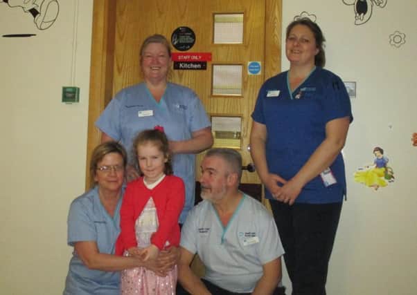 Brave Hollie with the staff who helped her to walk and talk again