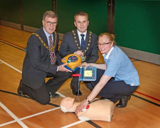 Mayor of Antrim and Newtownabbey, Councillor Thomas Hogg and John Mooney, President of Antrim Lions Club launching the new defibrillator grant scheme. They are pictured with Noreen Fitzpatrick from Antrim Forum who is demonstrating the use of the defibrillator.