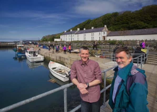 Michael Cecil and David Quinney mee at Rathlin harbour. the manor house is in the background. INBM08-16 S