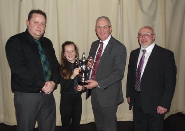 Pictured receiving a trophy from Danny Kennedy is Anna McKew  who achieved the highest overall mark. Also pictured is Keith Lyttle, Fiddle tutor and Conrad Clarke, Chairman of MACN.