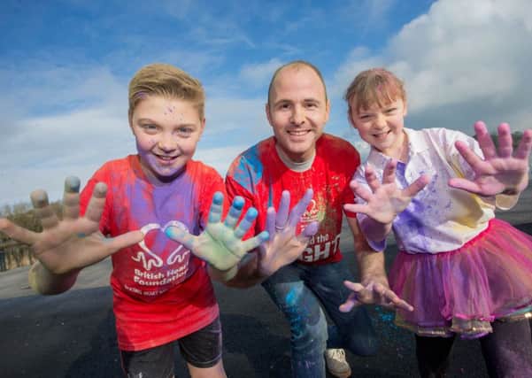 Calum and Alex McShane shower Lord Mayor of Armagh, Banbridge and Craigavon, Councillor Darryn Causby with colour launching the first Heart & Sole Colour Dash taking place on Sunday 17th April.