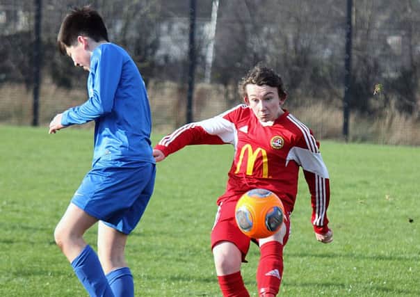 A Ballinamallard opponent takes evasive action as a Carniny Youth U-14 player clears his lines. INBT 08-833H
