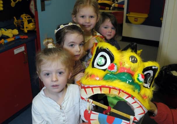 Emile, Lily, Olivia and Holly welcome the Chinese dragon to Victoria Primary School Nursery Unit. INCT 07-201-AM
