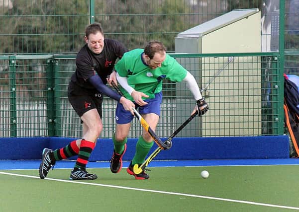 A Ballymena player holds off a determined challenge from a PSNI opponent during Saturday's match against PSNI. INBT 08-834H