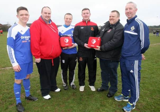 Ongoing work of Trust is praised. Gareth and David Lowry pictured last year presenting Ahoghill Thistle players Alan Moore and Gary Tennant, and Ahoghill Rovers players Chris Duff and Derek Livingstone, with defibrillators on behalf of the Stephen Lowry Memorial Trust. Now the Trust is donating a defibrillator to the Dr. John Mckelvey Community Centre. (Editorial Image)