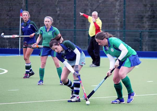 Ballymena and Grosvenor battle for possession during Saturday's match, as the umpire looks on. INBT 09-853H