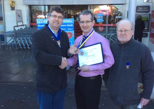 Rotary Club President Gerry McElvogue presents the Paul Harris Award to Brian Campbell, manager of Eurospar, Scarva Road. Also in picture is Rotarian Eddie Carr.