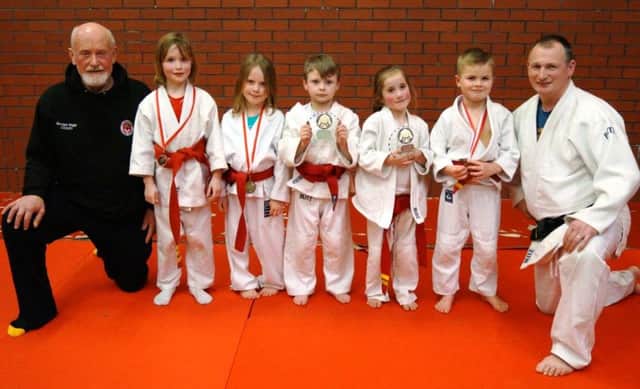 5-7 year-old award winners with their medals and trophies with coaches Richard Briggs and Philip Duncan.