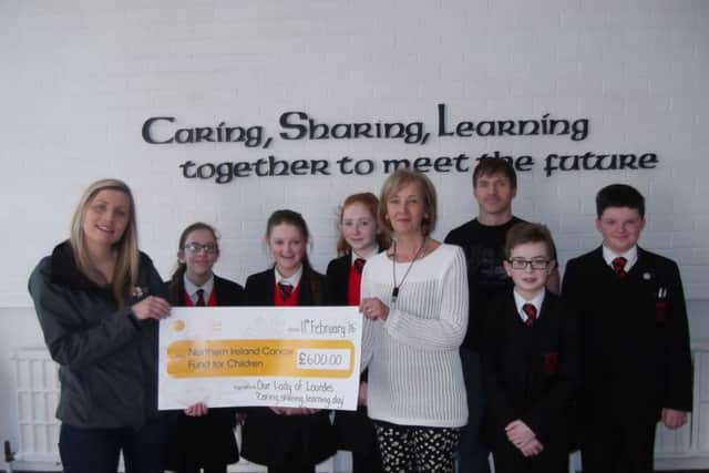 Mrs Delargy, Senoir Teacher and Head of the LRC, presents the cheque to Rebecca Spiers from the Cancer Fund for Children.  Also included are Jemma McLeister, Hannah Gribbon, Ellen Kearns, Mr McMaster, Owen McVeigh and OdhrÃ¡n Richards. inbm10-16s