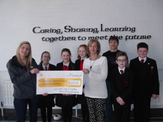 Mrs Delargy, Senoir Teacher and Head of the LRC, presents the cheque to Rebecca Spiers from the Cancer Fund for Children.  Also included are Jemma McLeister, Hannah Gribbon, Ellen Kearns, Mr McMaster, Owen McVeigh and OdhrÃ¡n Richards. inbm10-16s