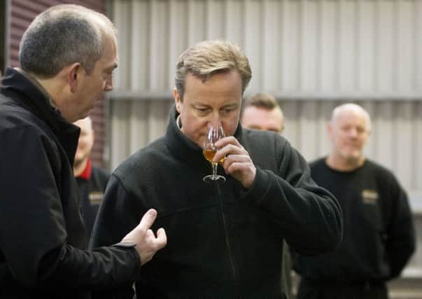 Prime Minister David Cameron smells a dram of whiskey as Manager of the Distillery Colum Egan explains the fragrance of whiskey during his visit to Bushmills distillery in Co Antrim as he continues a tour of the UK setting out the case for staying in the European Union. Photo: Liam McBurney/PA Wire