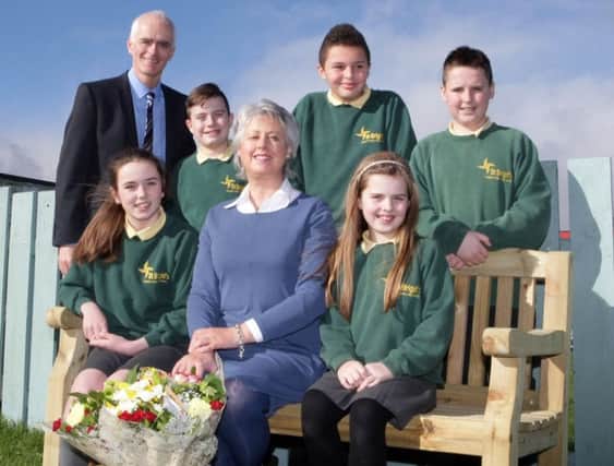 FAREWELL. Ms Muriel McConaghy, who has retired from her teaching post at St Brigid's PS after 24yrs, pictured along with Principal Mr Malachy Conlan and pupils, who presented her with gifts. In turn, Muriel presented a bench to the school.INBM9-16 016SC.