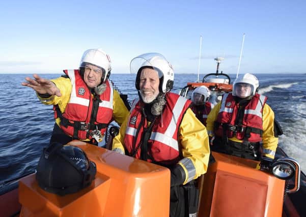 Justice Minister David Ford takes the helm of the Lough Neagh Rescue lifeboat with coxswain Paul Magee. Picture: Michael Cooper