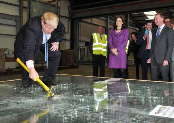 London Mayor Boris Johnson checks out the strength of the glass made by Magherafelt company Windell as Northern Ireland Secretary of State Theresa Villiers and David Henry look on.INMM0916-344