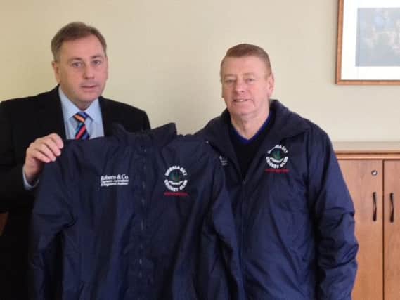 George Roberts (left) of sponsors George Roberts & Co Accountants and Registered Auditors presents a jacket to Graham Kenny Derriaghy Club President.