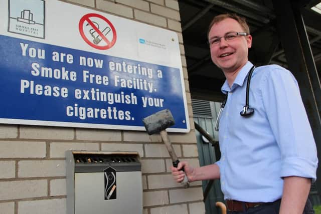 Consultant Cardiologist Dr Andrew Hamiton removing ashtrays at the Ulster Hospital.