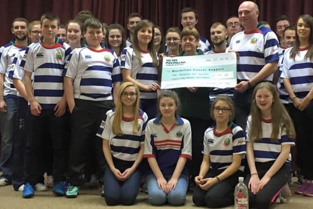 Cheque presentation of £1195.30 being received by Margaret Johnston from McMillan cancer, being presented by club president Trevor Wilson and Club secretary Teresa Conon, with club members looking on.