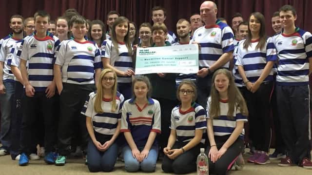 Cheque presentation of Â£1195.30 being received by Margaret Johnston from McMillan cancer, being presented by club president Trevor Wilson and Club secretary Teresa Conon, with club members looking on.