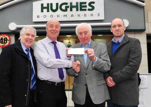 Gregory Hughes of Hughes Bookmakers Dungannon pictured as he hands over a cheque for Â£850 to Pat O'Kane representing Marie Curie Cancer Care. Included in the picture are Kevin Hughes (Head of Sport at the Mid-Ulster Mail & Tyrone Times) and Seamus Donnelly (Sports Reporter). The money is proceeds from the Mid-Ulster Mail & Tyrone Times Cheltenham charity bets.INTT1415-332