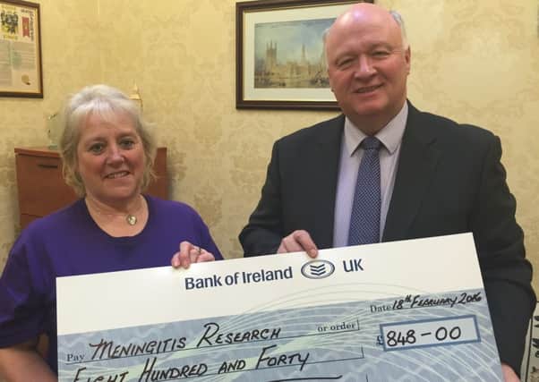 David Simpson MP presents a cheque to Mary Stafford from monies raised from the recent business breakfast.