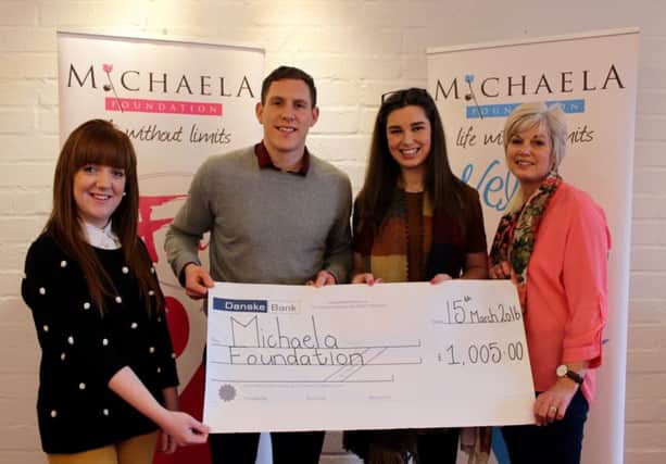Orlagh McClinton and Patricia McClinton hand over the money they raised to John McAreavey and Janine Diamond from the Michaela Foundation.