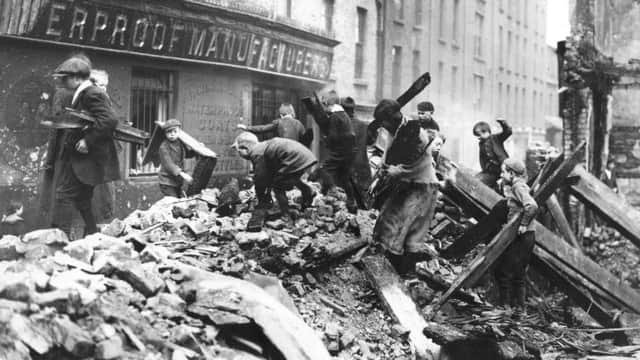Poor children of Dublin collecting firewood from the ruined buildings damaged in the Easter Rising.   (Photo by Central Press/Getty Images)