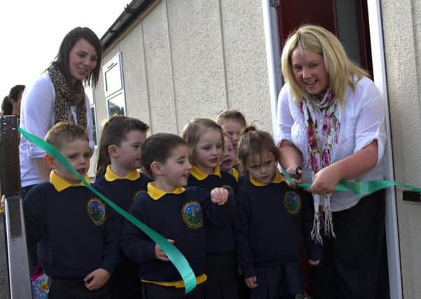 Pictured in 2011, Mona Ui Dhochartaigh cuts the ribbon at the then new Gaelscoil Aodha Rua in Dungannon with her colleague Patricia McAnulty and pupils. Education Minister John O'Dowd has announced a brand new brick built school for Gaelscoil Aodha Rua