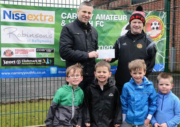 Gary Olphert, manager of Robinsons Nisa Extra, Cullybackey Road, presents Billy O'Flaherty and players with sponsorship for the Carniny Youth Football Development Centre. INBT 12-899H