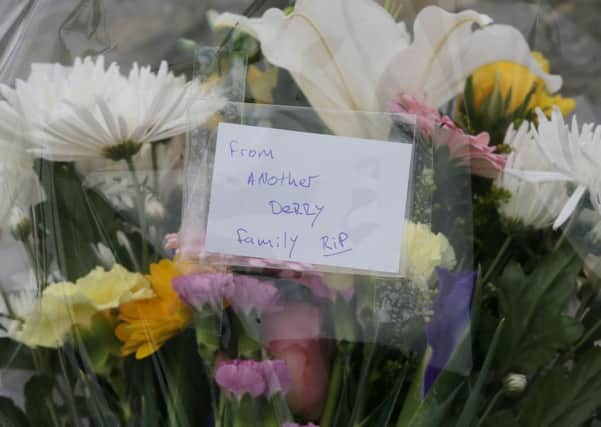 Flowers left at the scene at Buncrana Pier in Co Donegal after five people, including at least two children, have been killed and a baby girl is in hospital after a car they were in slipped from the pier