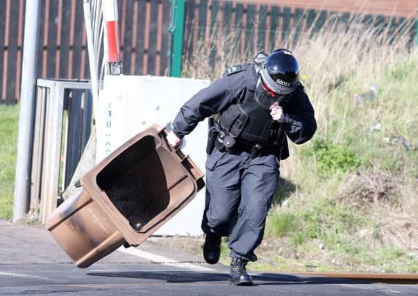 A PSNI officer removes the bin from the tracks.